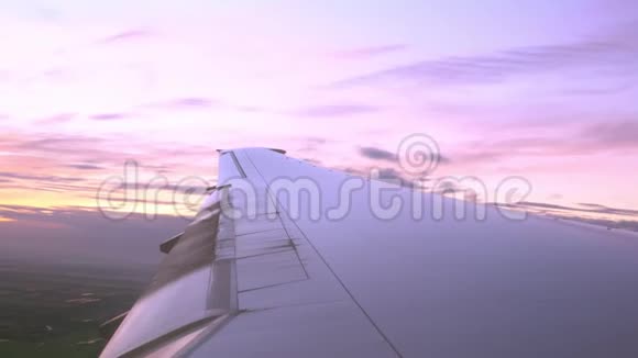 飞行中的飞机翼从窗外眺望黄昏的天空视频的预览图