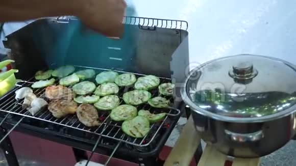 园舍烧烤过程在烧烤派对中一个人给煤点火酋长正在炸鸡和蔬菜视频的预览图