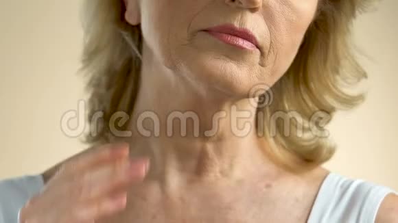 中年妇女仔细检查她颈部和胸部的皱纹皮肤视频的预览图