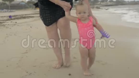妈妈带着女儿赤脚在海滩上散步视频的预览图