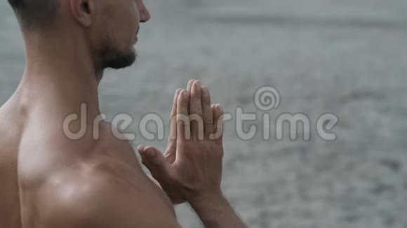 男子练瑜伽时的侧视双手并拢并拢视频的预览图