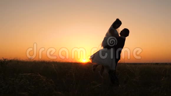 日落时分男人围着妻子转在蜜月中相爱的年轻家庭视频的预览图