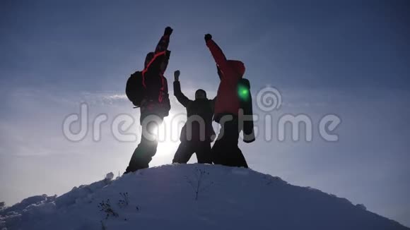 阿拉斯加的旅行者来到雪山的山顶为战胜冬日的日落而欢欣鼓舞人的团队工作视频的预览图