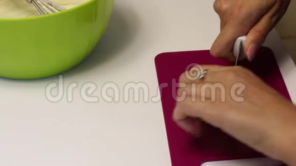 一个女人正在磨黑巧克力用刀在切割板上做甜点视频的预览图
