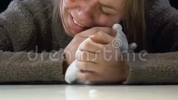 女人拥抱玩具喝抗抑郁药为失去的女儿哭泣视频的预览图