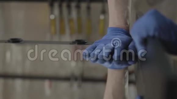 把木匠戴着手套的手按在镜面上粘在木板上手的概念视频的预览图