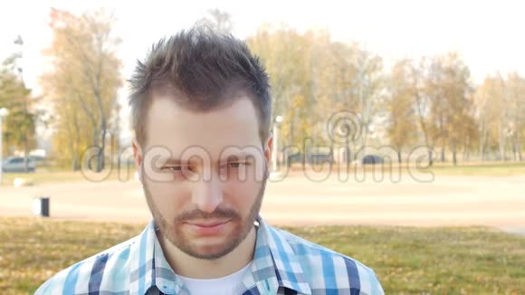 一个外表漂亮的无胡子时尚男士抬起眼睛戴上黑色眼镜特写镜头慢镜头复制空间视频的预览图