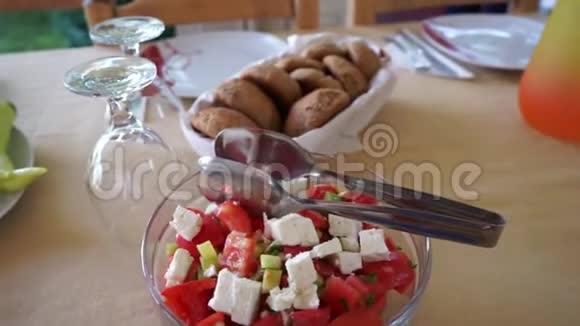 室外夏季露台咖啡馆提供服务的桌子番茄沙拉白奶酪和青椒一篮子面包和酒杯视频的预览图