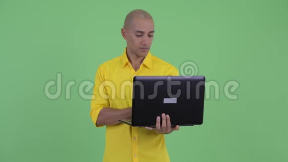 快乐的英俊的秃头商人思考笔记本电脑视频的预览图