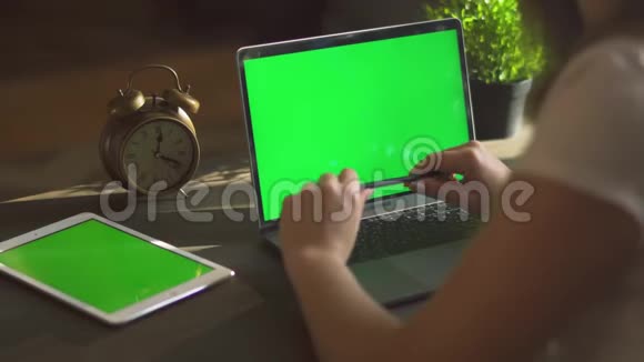 用绿色屏幕在笔记本电脑上打字的女性手的特写镜头使用绿色笔记本的女性视频的预览图