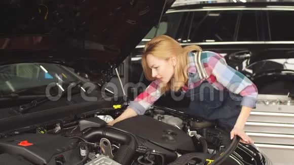 发动机趋势监测可爱的金发女郎学习修理汽车视频的预览图