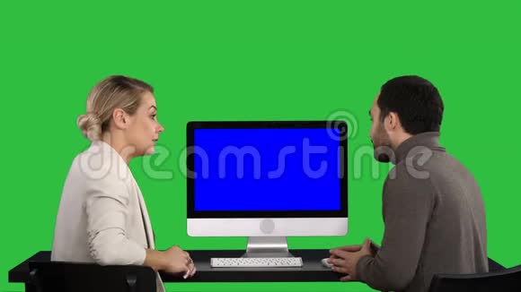 商务人士在电脑显示器周围开会谈论绿色屏幕上屏幕上的内容Chroma视频的预览图