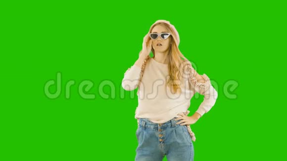 年轻漂亮的金发女郎穿着时髦的衣服和眼镜笑起来愉快而热情时尚的镜头绿色的视频的预览图