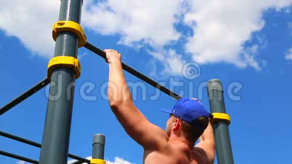 概念运动动机在一个阳光明媚的日子里一个肌肉发达的男人在户外的水平杆上拉了起来运动员视频的预览图