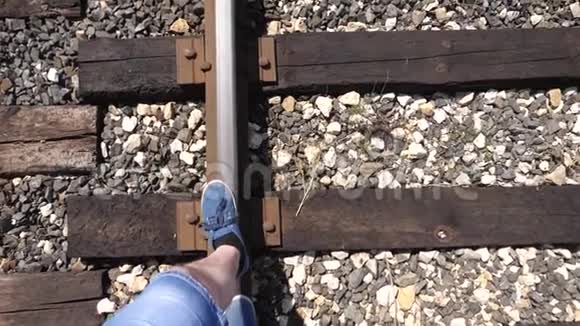 旅行者的腿在铁路上铁轨上行驶特写镜头游客踩着枕木1乘客落在后面视频的预览图