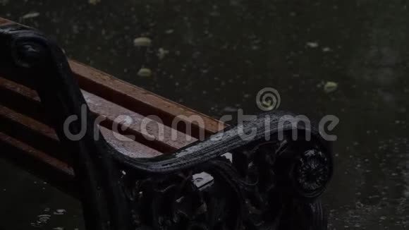 在雨中的公园里坐着老式的长凳近景视频的预览图