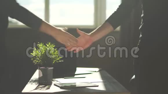 男的双手互相握手亲密起来商务协议后办公室里的两个人握手视频的预览图