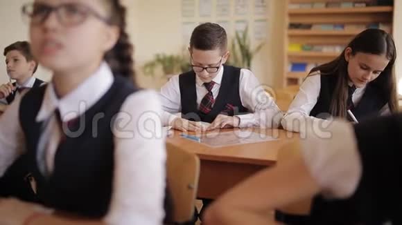 穿校服的淘气学生上课时制作纸飞机视频的预览图