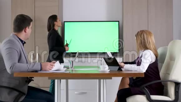 女商人在绿色屏幕电视前的会议室里讲话视频的预览图