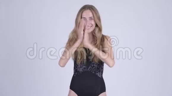 穿着泳衣拍手的年轻金发美女视频的预览图