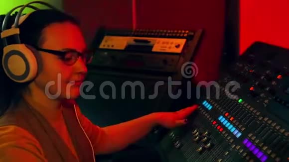 女士DJ在耳机和眼镜混合轨道迪斯科混合控制台视频的预览图