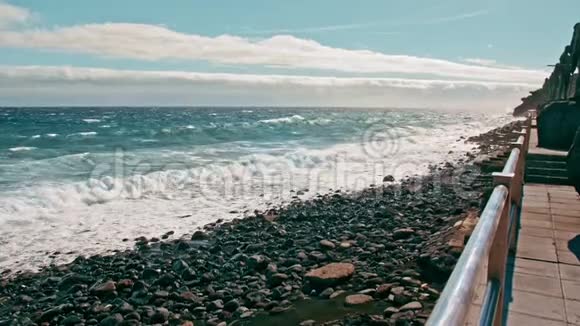 海上冲浪海洋海岸波浪在绿松石水和白色泡沫上水滴飞入镜头火山黑色的石头海岸视频的预览图