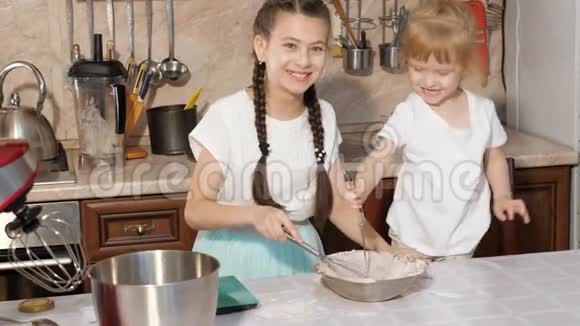 两个姐妹在一个碗里搅拌配料视频的预览图