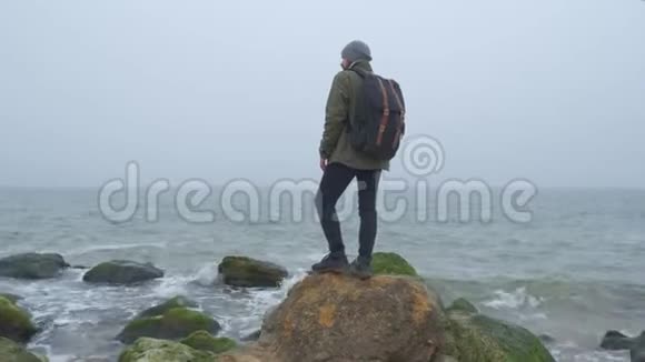 一个孤独的游客在荒野与石山和海岸海岸和美好的感情情感的概念视频的预览图