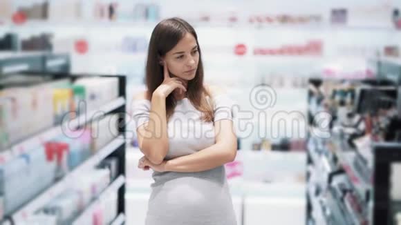 化妆品店的女孩肖像认为买哪种产品慢动作视频的预览图