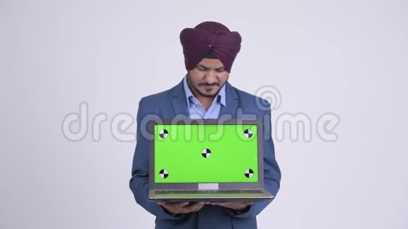 印度锡克族长胡子的快乐商人一边看着笔记本电脑一边思考视频的预览图