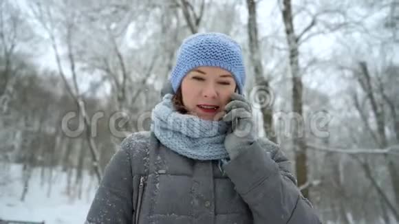 冬天公园里快乐的女人在打电话视频的预览图