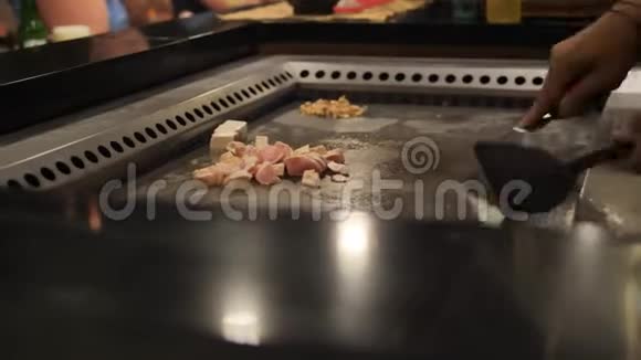亚洲厨师在一个大炉子上为观众切鸡肉视频的预览图