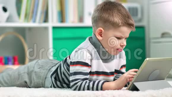 一个学龄前的男孩正在用他的平板电脑上网视频的预览图