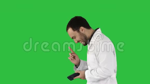 医生在绿色屏幕上打电话后边走边笑Chroma键视频的预览图