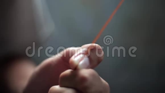 男少年用黑色剪刀剪棕色的线视频的预览图