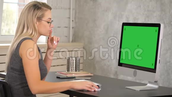 有魅力的成熟女商人在她的工作站工作电脑绿色屏幕模拟显示视频的预览图