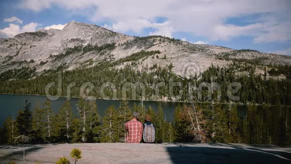 后景幸福浪漫情侣坐在史诗山湖全景拍照在约塞米蒂公园慢动作视频的预览图