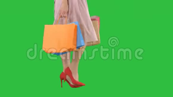部分身体美丽的女性纤细的腿女孩拿着一个纸购物袋在绿色屏幕上Chroma键视频的预览图