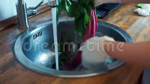 女手戴手套在厨房水槽里洗甜菜根视频的预览图