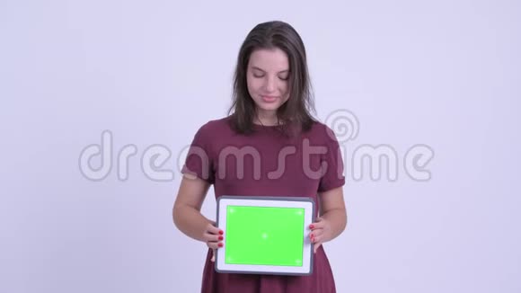 快乐年轻美丽的孕妇思考显示数字平板电脑视频的预览图