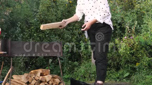 一个穿白衬衫的女人把木柴扔进火里假期概念视频的预览图