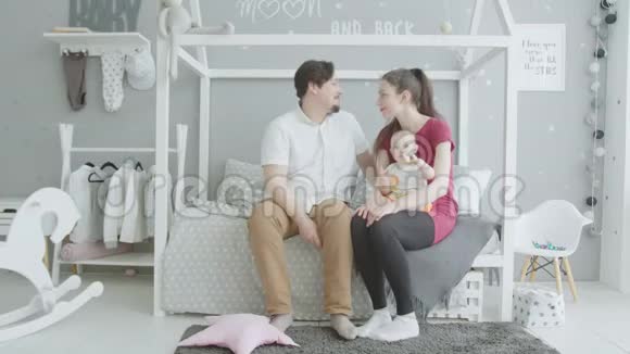 快乐的父母在卧室里和女婴玩耍视频的预览图