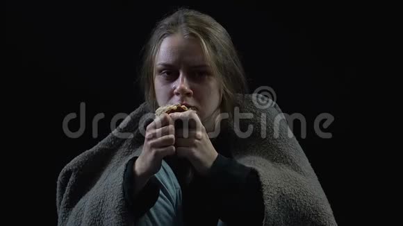 可怜的女人被肮脏的毯子覆盖着哭着吃面包皮贫穷战争视频的预览图