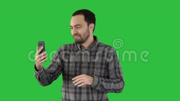 在一个男人的电话上Videoblog博客Vlog在绿色屏幕上Chroma键视频的预览图