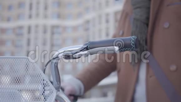 男子的手把手放在自行车的车把上并开始骑现代摩天大楼就在背景中视频的预览图