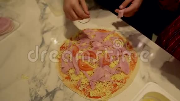 孩子们手做披萨在蛋糕上加火腿视频的预览图