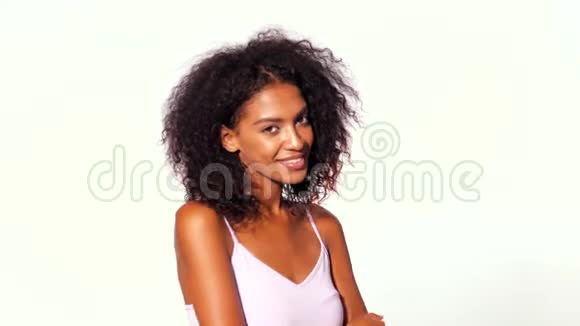 漂亮的非裔美国女人她的头发是粉红色的微笑着在白色的墙壁背景上调情视频的预览图