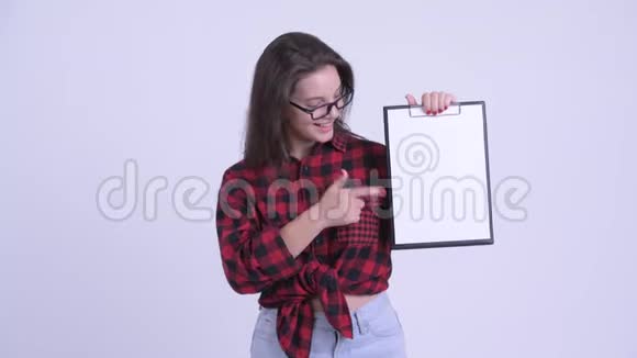 快乐的年轻漂亮的时髦女郎展示剪贴板竖起大拇指视频的预览图