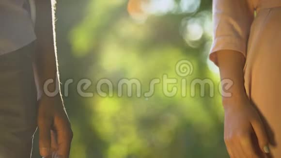 多种族夫妇在阳光公园牵手浪漫和亲密特写视频的预览图