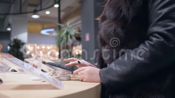 电子商店购物皮衣女顾客选购现代手机视频的预览图